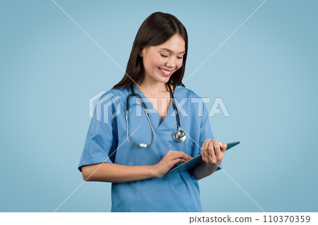 Nurse in blue scrubs with a tablet, perfect for medical tech themes 110370359