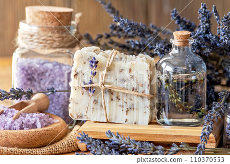 Wellness treatments with lavender flowers on wooden table. Spa still-life. Essential oils, sea salt and handmade soap. Natural herb cosmetic with lavender flowers Wellness treatments with lavender flowers on wooden table. Spa still-life. Essential oils, sea salt and handmade soap. Natural herb cosmetic with lavender flowers 110370553