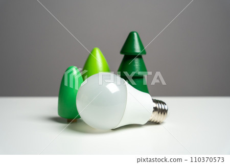 Energy saving light bulb surrounded by forest trees. Harmonious blend of sustainability and nature, showcasing the positive impact of energy-efficient choices on the environment. 110370573