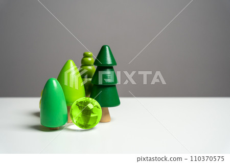 Green globe planet earth surrounded by forest trees. Environmental protection. Conservation of forests and nature reserves. Innovative technologies to reduce the impact on the environment. 110370575