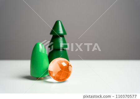 Orange globe planet earth and trees. The concept of a threat to forests, nature and animal diversity of the planet. Global warming, climate destabilization. The greenhouse effect and its way out. 110370577