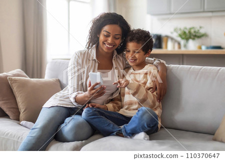 Happy African American Mom And Little Son Relaxing With Smartphone At Home 110370647