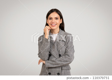 Confident businesswoman smiling, hand on chin, thoughtful pose Confident businesswoman smiling, hand on chin, thoughtful pose 110370731