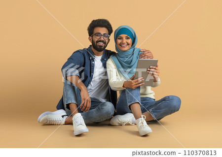 Online Entertainment. Happy Young Muslim Couple Using Digital Tablet Together Online Entertainment. Happy Young Muslim Couple Using Digital Tablet Together 110370813