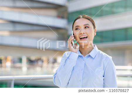 Korean entrepreneur woman engaged in phone call in urban area 110370827