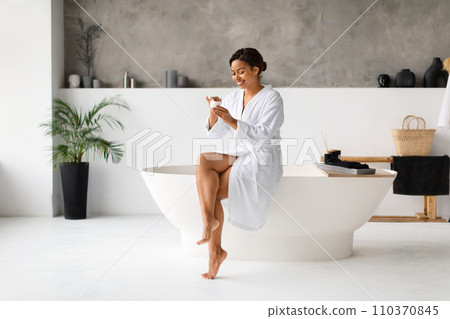 Skincare. Happy Young African American Woman Applying Cream In Bathroom Skincare. Happy Young African American Woman Applying Cream In Bathroom 110370845