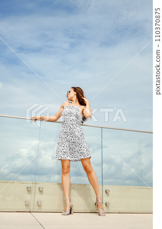 Full length portrait of pretty woman in sundress on balcony 110370875