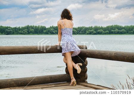 Unrecognizable woman standing on wooden pier 110370919