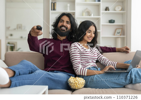 Loving young indian married couple relaxing at home Loving young indian married couple relaxing at home 110371226