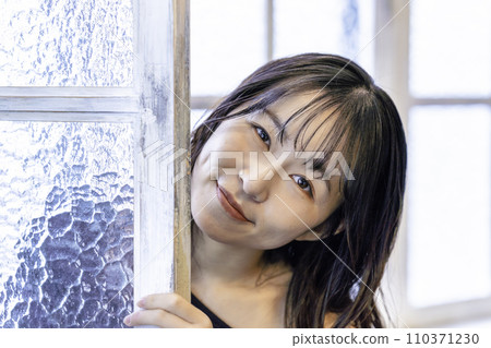 穿著黑裙子的年輕女子從窗戶偷看 110371230