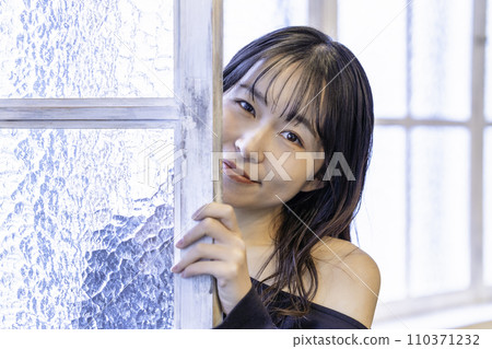 穿著黑裙子的年輕女子從窗戶偷看 110371232