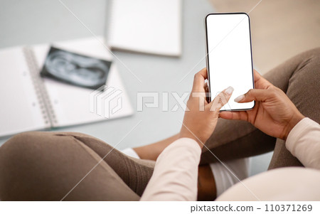 Cropped of pregnant black woman using phone with blank screen Cropped of pregnant black woman using phone with blank screen 110371269