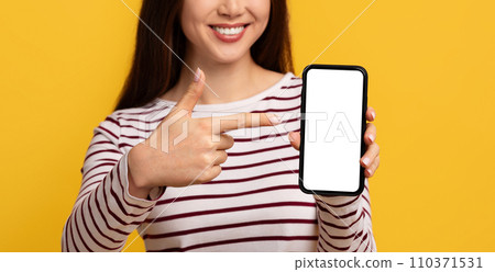 Cell phone with white empty screen in smiling lady hand 110371531