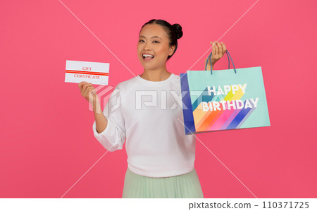 Beautiful Asian Woman Showing Gift Certificate And Happy Birthday Paper Bag Beautiful Asian Woman Showing Gift Certificate And Happy Birthday Paper Bag 110371725