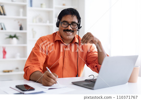 Cheerful middle aged man employee working from home office Cheerful middle aged man employee working from home office 110371767
