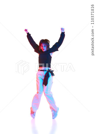 Young artistic woman in casual outfit dancing, performing hip hop isolated over white background in neon light 110371816