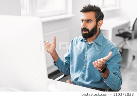 Surprised indian male office worker reacting to computer screen Surprised indian male office worker reacting to computer screen 110371828