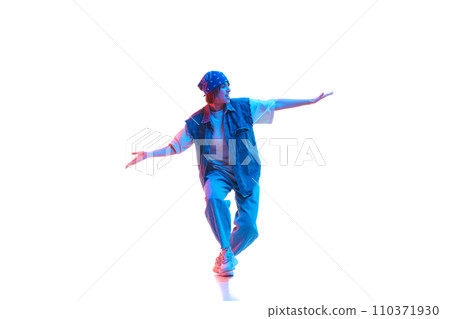 Young girl wearing casual jean clothes and head accessories dancing hip hop isolated over white background in neon light 110371930