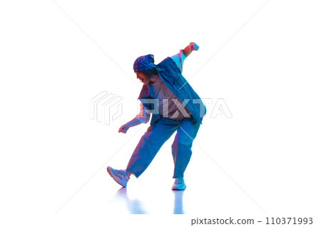 Stylish young girl in casual clothes in sport style dancing contemp, hip hop isolated over white background in neon light Stylish young girl in casual clothes in sport style dancing contemp, hip hop isolated over white background in neon light 110371993