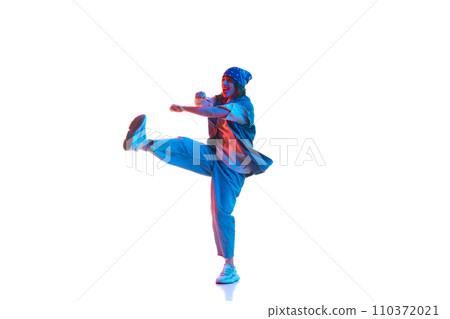 Stylish young girl in casual clothes in sport style dancing contemp, hip hop isolated over white background in neon light Stylish young girl in casual clothes in sport style dancing contemp, hip hop isolated over white background in neon light 110372021