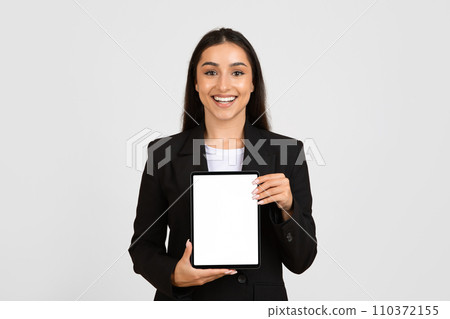 Cheerful businesswoman showcasing blank tablet screen Cheerful businesswoman showcasing blank tablet screen 110372155