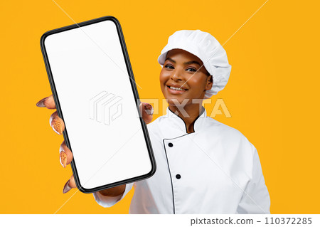 Cheerful African American Cooker Lady Showing Phone With Blank Screen Cheerful African American Cooker Lady Showing Phone With Blank Screen 110372285