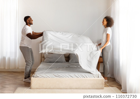 Black Couple Making Bed After Sleep Covering With Blanket Indoor Black Couple Making Bed After Sleep Covering With Blanket Indoor 110372730