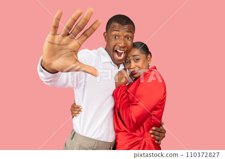 Black man gesturing stop with a fearful look, woman clinging to him Black man gesturing stop with a fearful look, woman clinging to him 110372827