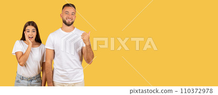 Two cheerful young adults wearing plain white t-shirts and jeans stand 110372978