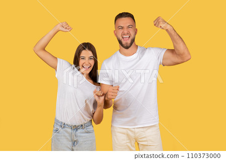 Excited young couple in white t-shirts showing off their muscles and celebrating success Excited young couple in white t-shirts showing off their muscles and celebrating success 110373000
