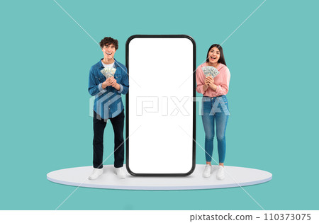 Teens with cash celebrating by large blank smartphone Teens with cash celebrating by large blank smartphone 110373075