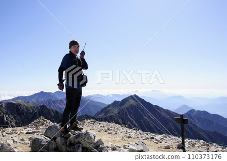 一名男子在山頂使用收音機 一名男子在山頂使用收音機 110373176