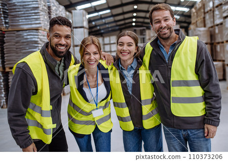 Full team of warehouse employees standing in warehouse. Team of workers in reflective clothing in modern industrial factory, heavy industry, manufactrury. 110373206