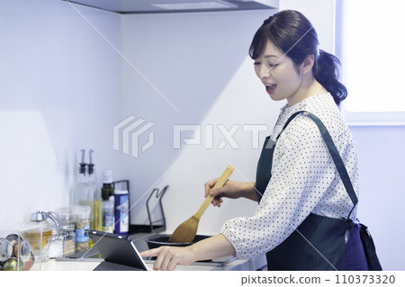 穿著圍裙煮飯的中年婦女 110373320