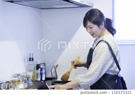 穿著圍裙煮飯的中年婦女 110373321
