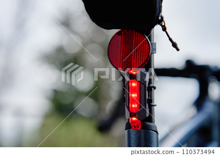 Glowing bicycle taillight. Red stop light for cyclist safety. Rear led light on bike 110373494