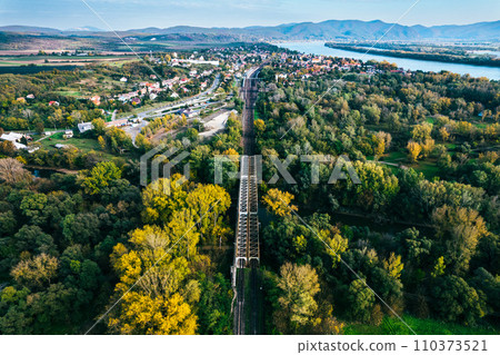 Aerial view of big metal railway bridge in Slovakia, in the middle of summer forest. Aerial view of big metal railway bridge in Slovakia, in the middle of summer forest. 110373521