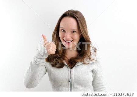 The joyful young woman pointing a finger The joyful young woman pointing a finger 110373637