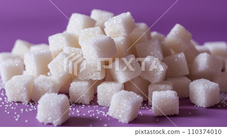 Pile of sugar cubes lying on top of each other, purple background 110374010