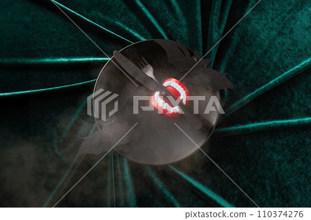 A halloween Plate with vampire teeth on a Green Velvet Background A halloween Plate with vampire teeth on a Green Velvet Background 110374276