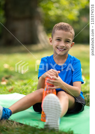 Cute boy in blue tshirt with orange bottle in hands Cute boy in blue tshirt with orange bottle in hands 110374558