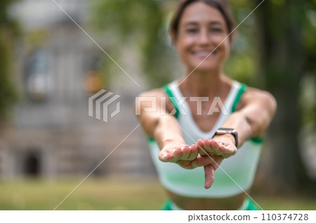 Cute dark-haired woman doing squats and smiling 110374728