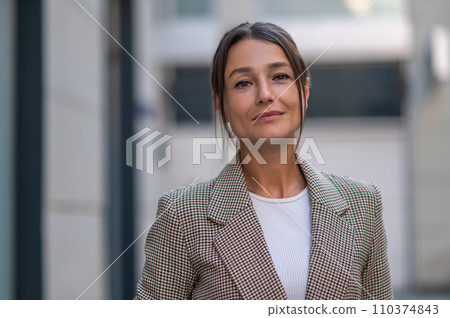 Woman wearing beige suit posing near urban building. Woman wearing beige suit posing near urban building. 110374843