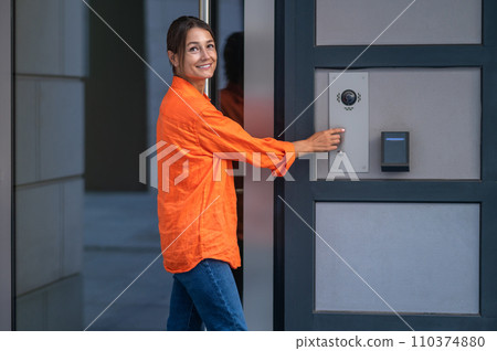 Woman using modern keypad system maintains control over access to her home. 110374880