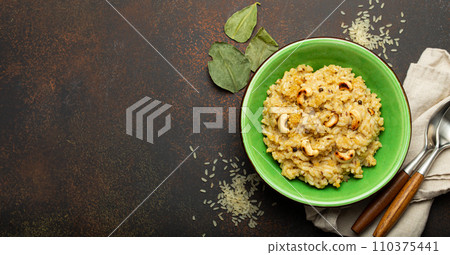 Ven Pongal (Khara Pongal), traditional Indian savoury rice dish made during celebrating Pongal festival, served in bowl top view on concrete rustic background, space for text 110375441