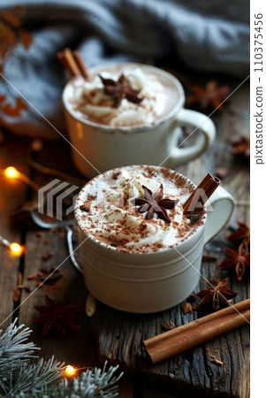 Two cups of hot chocolate with whipped cream, cinnamon and anise on a wooden background Two cups of hot chocolate with whipped cream, cinnamon and anise on a wooden background 110375456