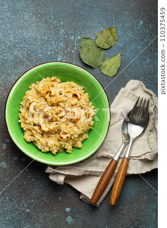 Ven Pongal (Khara Pongal), traditional Indian savoury rice dish made during celebrating Pongal festival, served in bowl top view on concrete rustic background 110375459