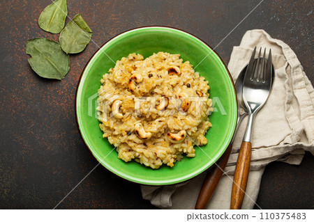 Ven Pongal (Khara Pongal), traditional Indian savoury rice dish made during celebrating Pongal festival, served in bowl top view on concrete rustic background Ven Pongal (Khara Pongal), traditional Indian savoury rice dish made during celebrating Pongal festival, served in bowl top view on concrete rustic background 110375483