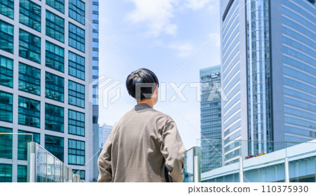 一位年輕的商人拿著筆記型電腦，抬頭看著天空，抬頭 110375930