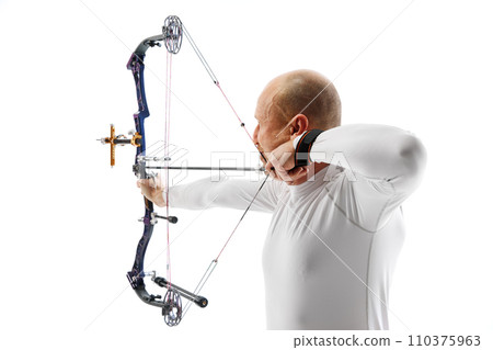 Man, professional archer training, aiming archery bow into target isolated over white studio background. Archery sport, competition Man, professional archer training, aiming archery bow into target isolated over white studio background. Archery sport, competition 110375963